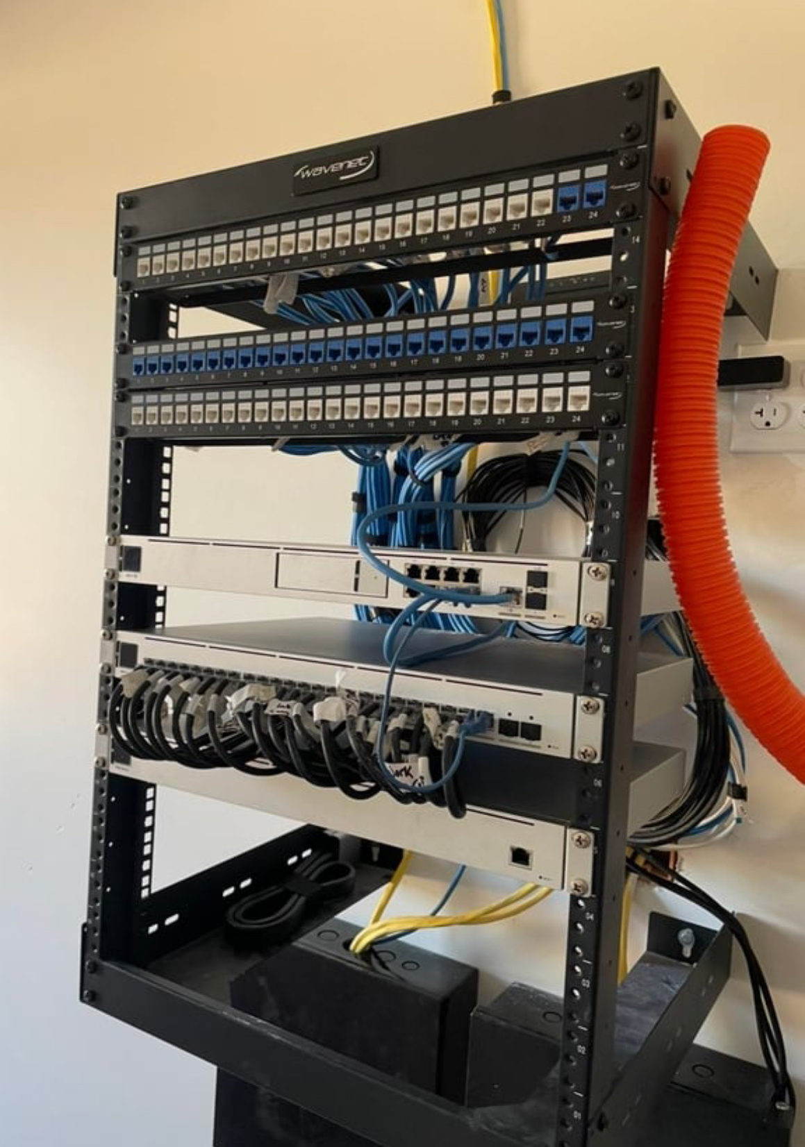 Organized network rack in home with flex conduit and organized ethernet cat6 lines