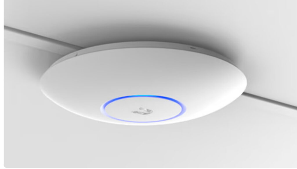 Ubiquiti Access Point mounted on the ceiling with blue light on
